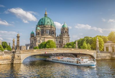 Berlin city guide.Berliner Dom.01 Berliner Dom and boat passing under the bridge in Berlin