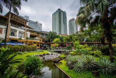 Manila city guide.Greenbelt Park.01 View of the Greenbelt Park against the backdrop of Manila's skyscrapers