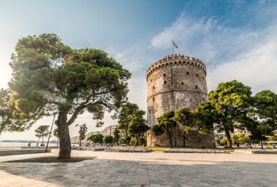 Thessaloniki city guide.White Tower.01 The White Tower in Thessaloniki bordered by trees