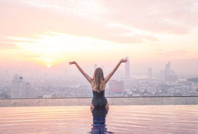 Escort at rooftop swimming pool to backdrop of Bangkok's skyline
