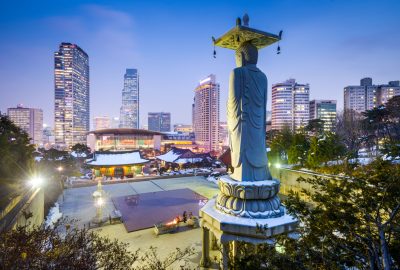 Seoul city guide.Bongeunsa Temple Gangnam district.01 The Buddhist temple Bongeunsa to the backdrop of the skyscrapers of Seoul's Gangnam-gu district by night