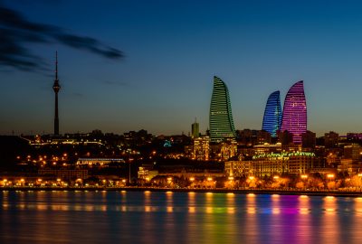 Baku city guide.Flame Towers and TV Tower.01 View from river at Flame Towers with night illumination in Baku