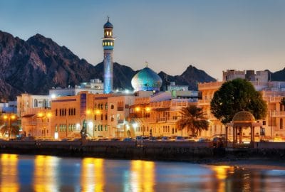 Muscat city guide.Muttrah Corniche.02 Muttrah Corniche in Muscat by evening with illuminated mosque and mountains to the backdrop