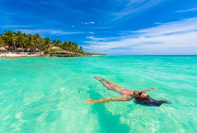 Cancun city guide.Tulum Riviera Maya.01 Woman swimming in sea of Riviera Maya in Tulum