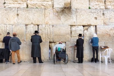 Jerusalem city guide.Wailing Wall.01 People standing at the Wailing Wall in Jerusalem