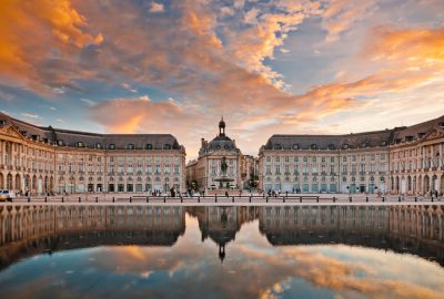Bordeaux city guide.Place de la Bourse.01 Place de la Bourse by evening reflected in the Water Mirror (Miroir d'eau) in Bordeaux