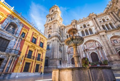 Malaga city guide.Cathedral of Malaga.01 Incarnation Cathedral (La Manguita) and fountain viewed from Plaza del Obispo in Malaga